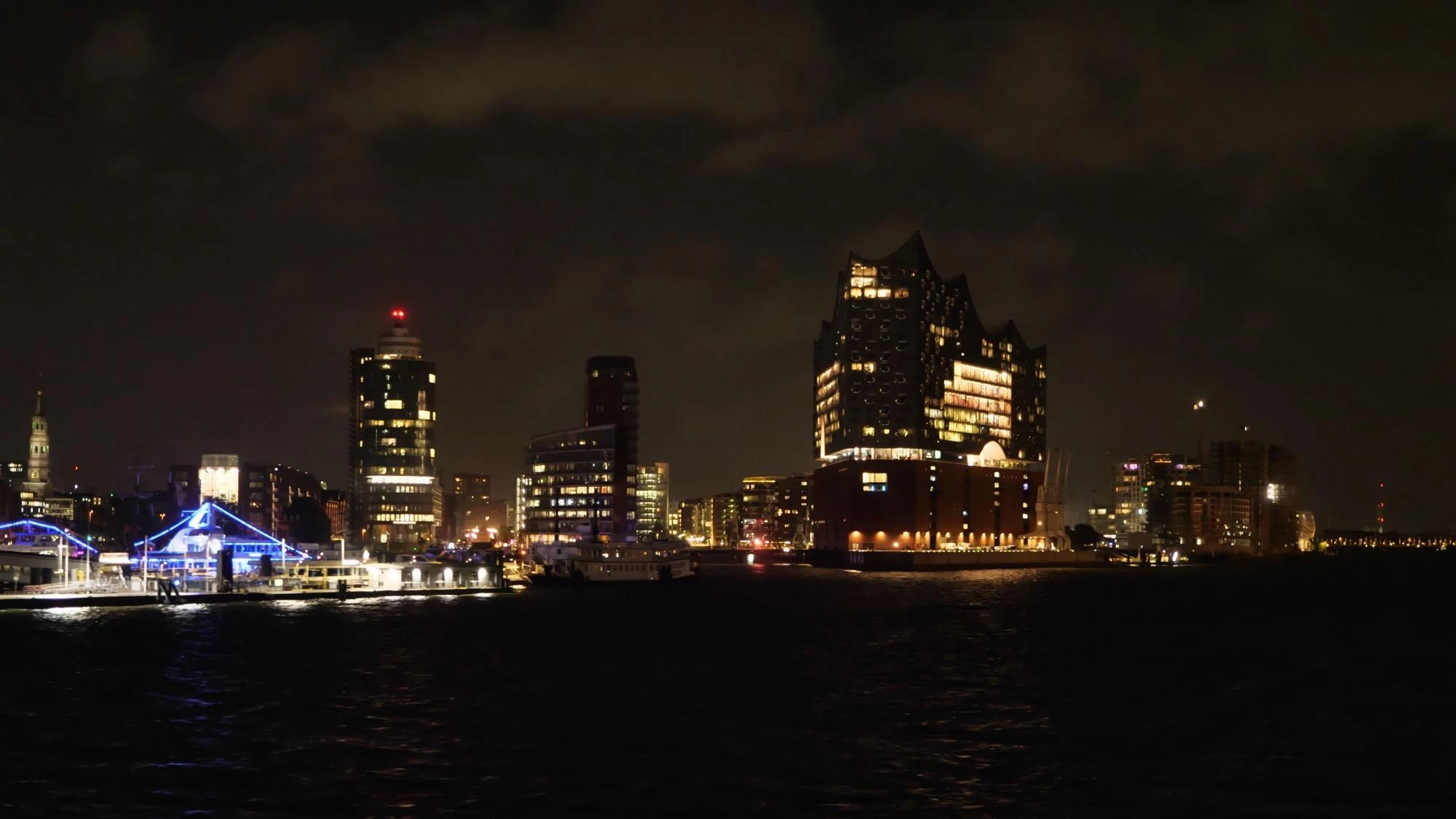 Die Hamburger HafenCity mit der beleuchteten Elbphilharmonie bei Nacht